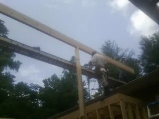 Carpenter setting a ridge beam over a new addition frame — Ice Dam Removal by Roofing Brothers in Missouri City