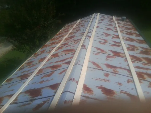 Rusted metal roof panels with new wood purlins before replacement — Storm Damage Roof Repair in Missouri City by Roofing Brothers
